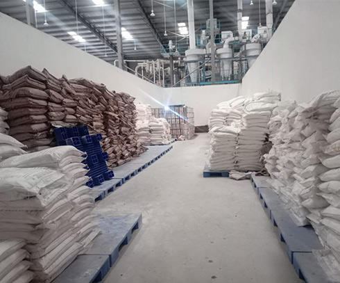 Aisle between stacked bags of raw material and stock inside the food plant
