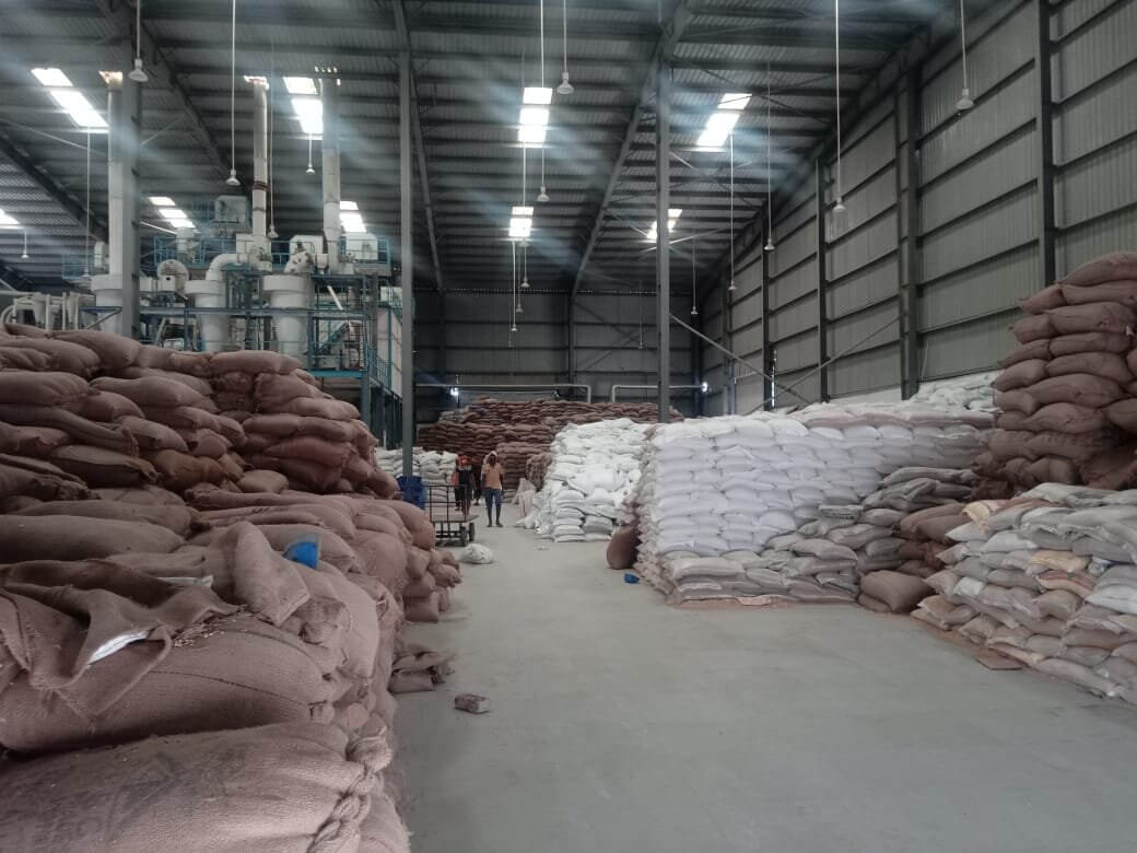 Raw-material storage and processing hall at the food manufacturing facility, with stacked sacks and a processing line