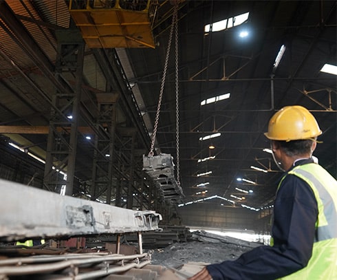 Industrial worker overseeing a suspended casting